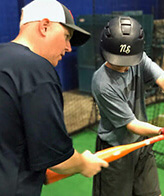 coach helping a young player with his swing